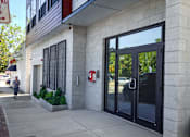 Thumbnail 34 of 36 - Modern building entrance with glass doors and concrete facade at 68 Beale Apartments, Quincy